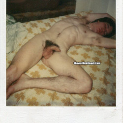 Nude male slut sprawled on a bed